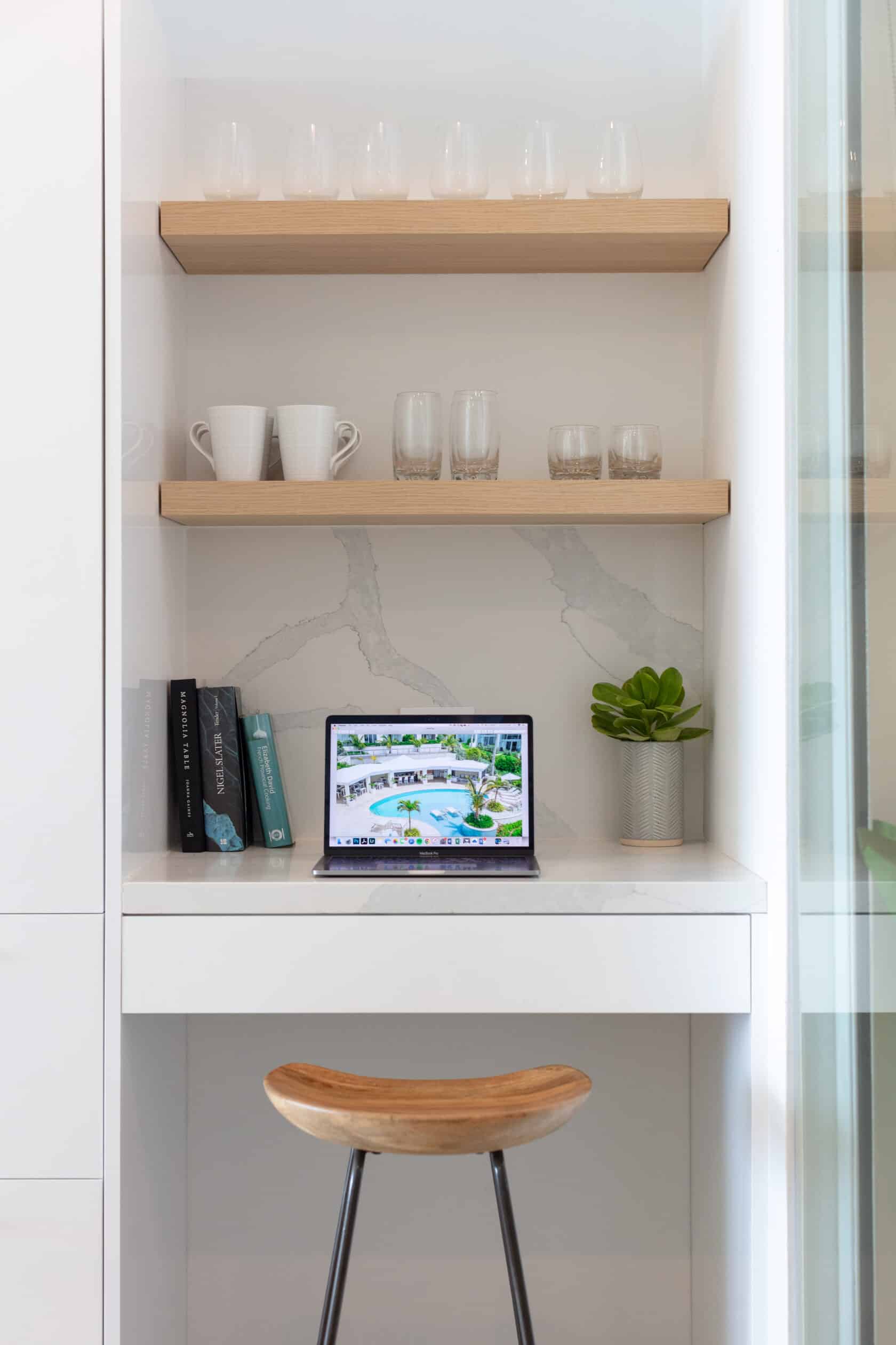 A laptop sits on a shelf in a kitchen in a Bermuda residence.