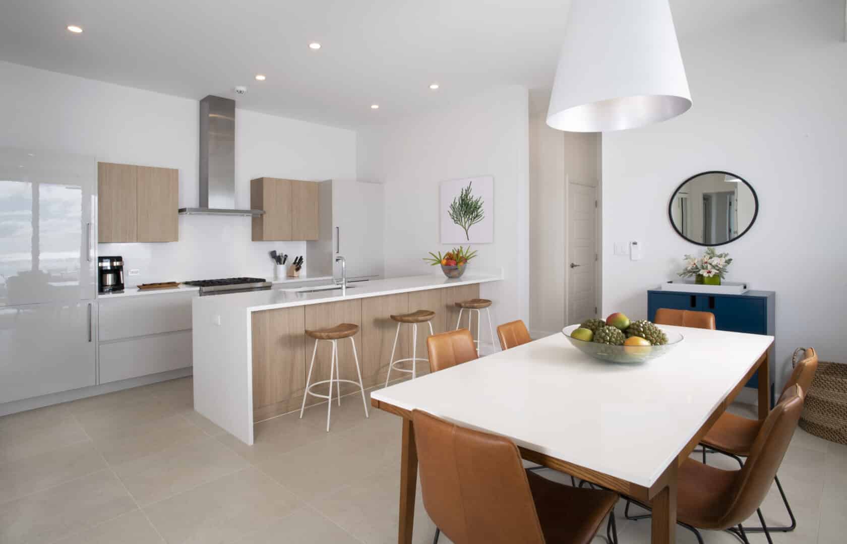 A white kitchen at the Bermuda Residences with a dining table and chairs.