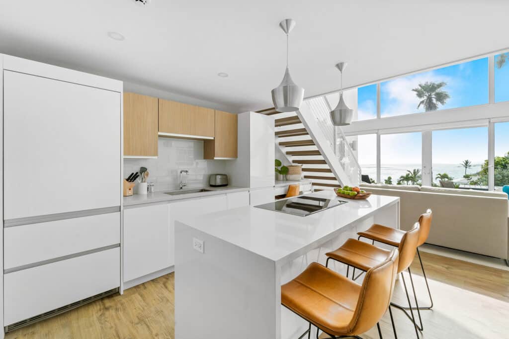 A modern kitchen with stools and a ocean view, perfect for Bermuda vacations.