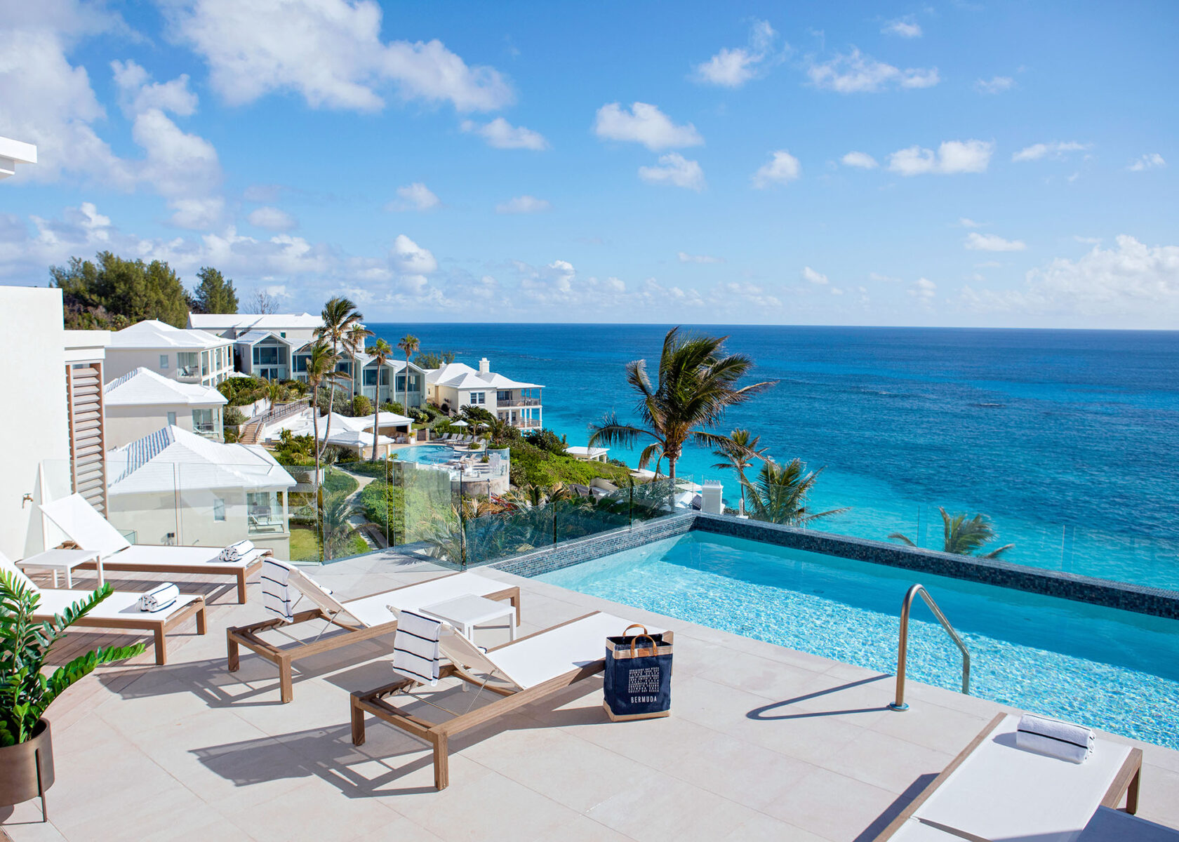 Enjoy a poolside view at this coastal resort featuring lounge chairs, an infinity pool, and the stunning blue ocean under a clear sky. Ideal for a Bermuda vacation rental, it promises unmatched relaxation just minutes away from vibrant Hamilton.